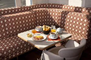 - une table avec un plateau de nourriture sur un canapé dans l'établissement Résidence du Grand Hôtel, au Plessis-Robinson