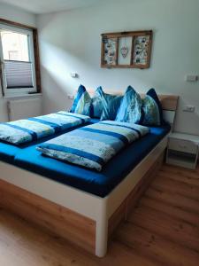 a bed with blue pillows on it in a room at Haus Jakob in Filzmoos