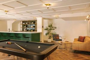 a living room with a pool table and a bar at FOUND Hotel Santa Monica in Los Angeles