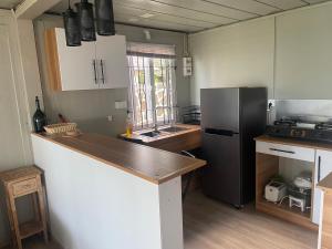een keuken met een zwarte koelkast en een aanrecht bij Tilakaz Kreol in Pointe d'Esny