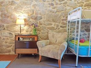 ein Schlafzimmer mit einem Etagenbett, einem Stuhl und einem Schreibtisch in der Unterkunft Quinta Estrada Romana - Albergue de Peregrinos in Cerdal
