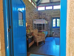 eine blaue Tür, die in ein Zimmer mit einem Schlafzimmer führt in der Unterkunft Quinta Estrada Romana - Albergue de Peregrinos in Cerdal