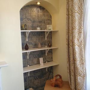 アバディーンにあるAlastrean Flatのカーテンのかかった部屋の棚のある壁