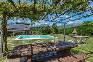 einen Hinterhof mit einem Pool und einer Bank in der Unterkunft Villa La Corte with amazing pool and garden in Colico