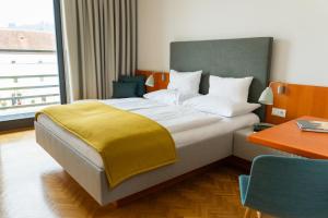 Un dormitorio con una cama con una manta amarilla. en Schloss Seggau en Leibnitz