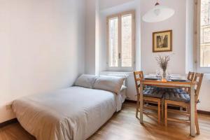 een slaapkamer met een bed en een bureau met een tafel bij Appartamento Al Zigànt - Top location in Bologna