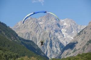 瓦盧伊斯的住宿－Huttopia Vallouise，挂在山前降落伞的人