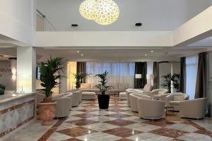 a hotel lobby with white chairs and tables and a waiting room at Hotel Don Ignacio in San José