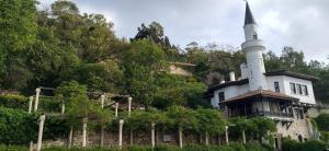 une maison avec une tour au sommet d'une colline dans l'établissement Victoria Family Hotel, à Balchik