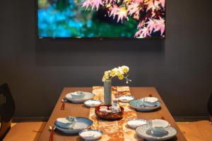 博揚薩戈的住宿－谷町君・星屋旅館・晴博・京都嵐山，一张带蓝白菜肴的桌子和花瓶