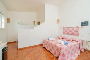 a white room with a table with a pink bed at Villa Corallia - Luxury Villa with sea view in Torre delle Stelle