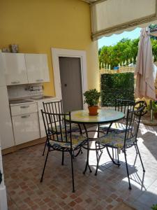 un patio con tavolo e sedie e una cucina di B&B A casa di Antonella a Scauri