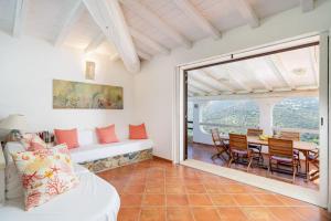 a living room with a couch and a table with chairs at Villa Corallia - Luxury Villa with sea view in Torre delle Stelle