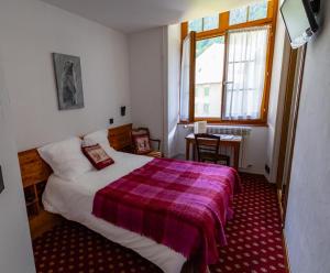 Chateau De La Muzelle في فينوسك: غرفة نوم بسرير وبطانية ارجوانية