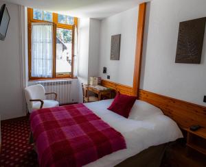 a bedroom with a bed with a red and white blanket at Chateau De La Muzelle in Vénosc