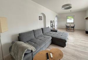 a living room with a gray couch and a table at Grosse Comfort-Ferienwohnungen Haus Bonni in Celle