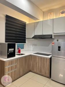 a kitchen with wooden cabinets and a white refrigerator at The Majestic Condo Ipoh Home Fairy 4 in Ipoh +15 photos