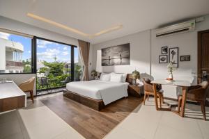 a hotel room with a bed and a desk at Tashi Oasis Hotel & Apartment Da Nang in Da Nang +63 photos