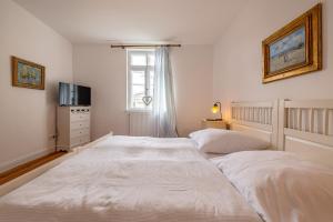 - une chambre blanche avec 2 lits et une fenêtre dans l'établissement Ferienwohnung Königssee, à Sassnitz