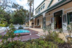 an exterior view of a house with a swimming pool at Evergreen Lodge in Stellenbosch