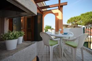 un patio con tavolo e sedie sul balcone. di Villaggio Clio a Bibione