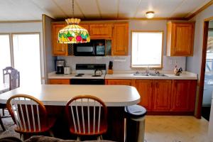 a kitchen with wooden cabinets and a kitchen island with chairs at Weller Island Bliss in Hammondsport +16 photos