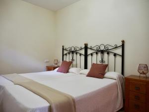 a bedroom with two beds with white sheets and red pillows at Apartamento Remoña 2 in Espinama
