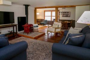 a living room with a blue couch and a tv at Green Acres Finger Lakes in Hammondsport