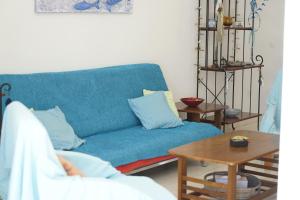 Sofá azul en la sala de estar con mesa en Searenity Seafront house - 50m from the beach, en Lárnaca
