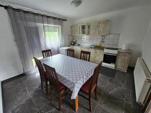 una cucina con tavolo e sedie di Apartman Mile a Smoljanac