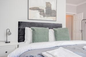 a bedroom with a bed with green and white pillows at Host & Stay - Bridge Street Apartments in Evesham