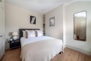 una camera bianca con letto e specchio di The Clapham House a Londra