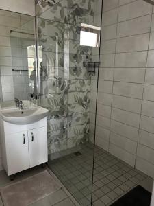 un bagno con lavandino e doccia di Guesthouse Grace At The Bay a Mossel Bay Altre 20 foto