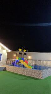 ein Spielplatz in einem Gebäude in der Nacht in der Unterkunft شاليه القمر في بهر in Ar Rawḑah