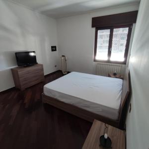 una camera con un grande letto e una televisione di Al settimo cielo a Gragnano