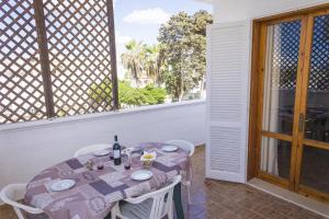 una mesa con un mantel púrpura en el balcón en Torre Lapillo Apartment Sea View - Happy Rentals, en Porto Cesareo
