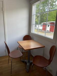 a table and two chairs in a room with a window at Stockholm Ängby Camping in Stockholm