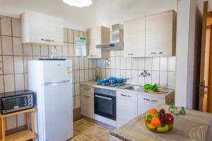 una cocina con electrodomésticos blancos y un bol de fruta en la barra en Torre Lapillo Apartment Sea View - Happy Rentals, en Porto Cesareo