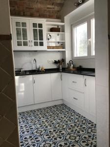 una cucina con armadietti bianchi e pavimento piastrellato di Melegis 1-Bed Cottage Sleeps 2 Pool & Garden a Melegis