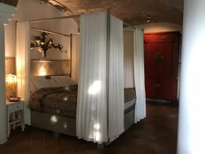 una camera da letto con un letto a baldacchino con uno specchio di Melegis 1-Bed Cottage Sleeps 2 Pool & Garden a Melegis