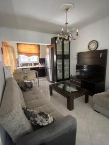 a living room with a couch and a piano at Golden House in Chrysoupolis