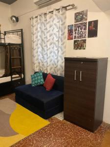 ein Wohnzimmer mit einem blauen Sofa und einem Etagenbett in der Unterkunft U.R.D.Ki Hostel in Anjuna