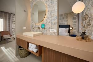 een badkamer met een wastafel en een spiegel bij Central Heritage Hotel in Split +88 foto's