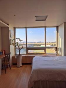 a bedroom with a bed and a large window at Cozy Bright Studio in Incheon