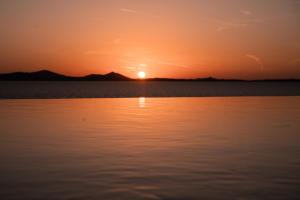 um pôr-do-sol sobre um corpo de água em Akre Hotel em Naxos Chora