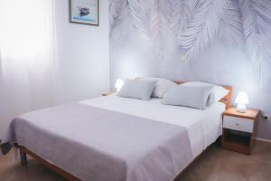 een slaapkamer met een wit bed en 2 witte kussens bij Vila Promajna 3 in Promajna