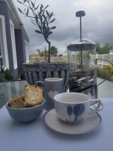 a cup of coffee and a bowl of bread on a table at Swaeltjie in Somerset West