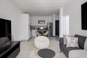 a living room with a couch and a tv and a table at Cozy retreat in Fourways in Johannesburg