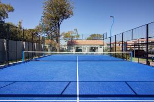 a tennis court with a net on it at Cozy retreat in Fourways in Johannesburg