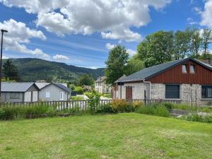 ein Haus mit einem roten Dach in einem Hof in der Unterkunft La Chaumière in Saulxures-sur-Moselotte